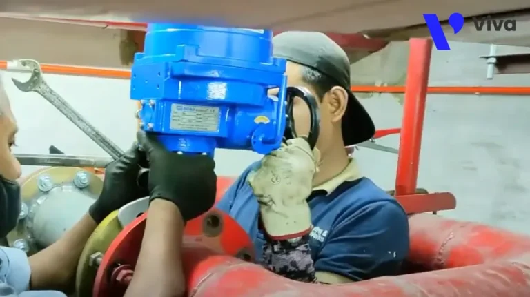 Công nhân đang căn chỉnh van sao cho trục van trùng với đường tâm của đường ống và cố định lại bằng đai ốc